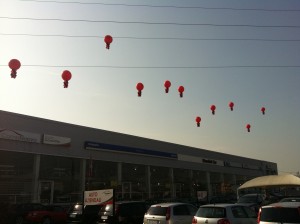 11 Mongolfiere promozionali rosse sospese a 10 metri di altezza sopra il tetto di una concessionaria