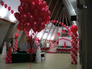 allestimento per una Festa aziendale natalizia: bouquet di palloncini, archi di palloncini ad elio e colonne di palloncini tutto in rosso e bianco