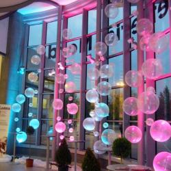 file di palloni sospesi trasparenti illuminati con luci colorate