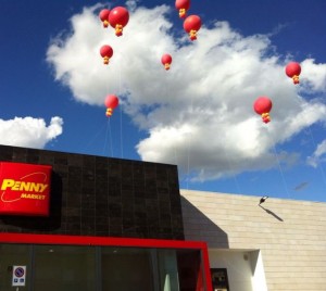 grande pallone personalizzato e gonfiato ad elio: in questo caso decine di palloni giganti rossi sul tetto del Penny Market
