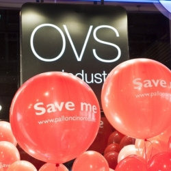palloni giganti rossi con stampa bianca, sfondo nero con logo OVS