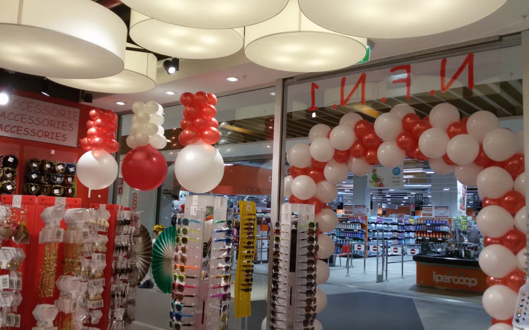 allestimento vetrine creativo: arco di palloncini bianchi e rossi e palloni giganti capovolti scendono dal soffitto